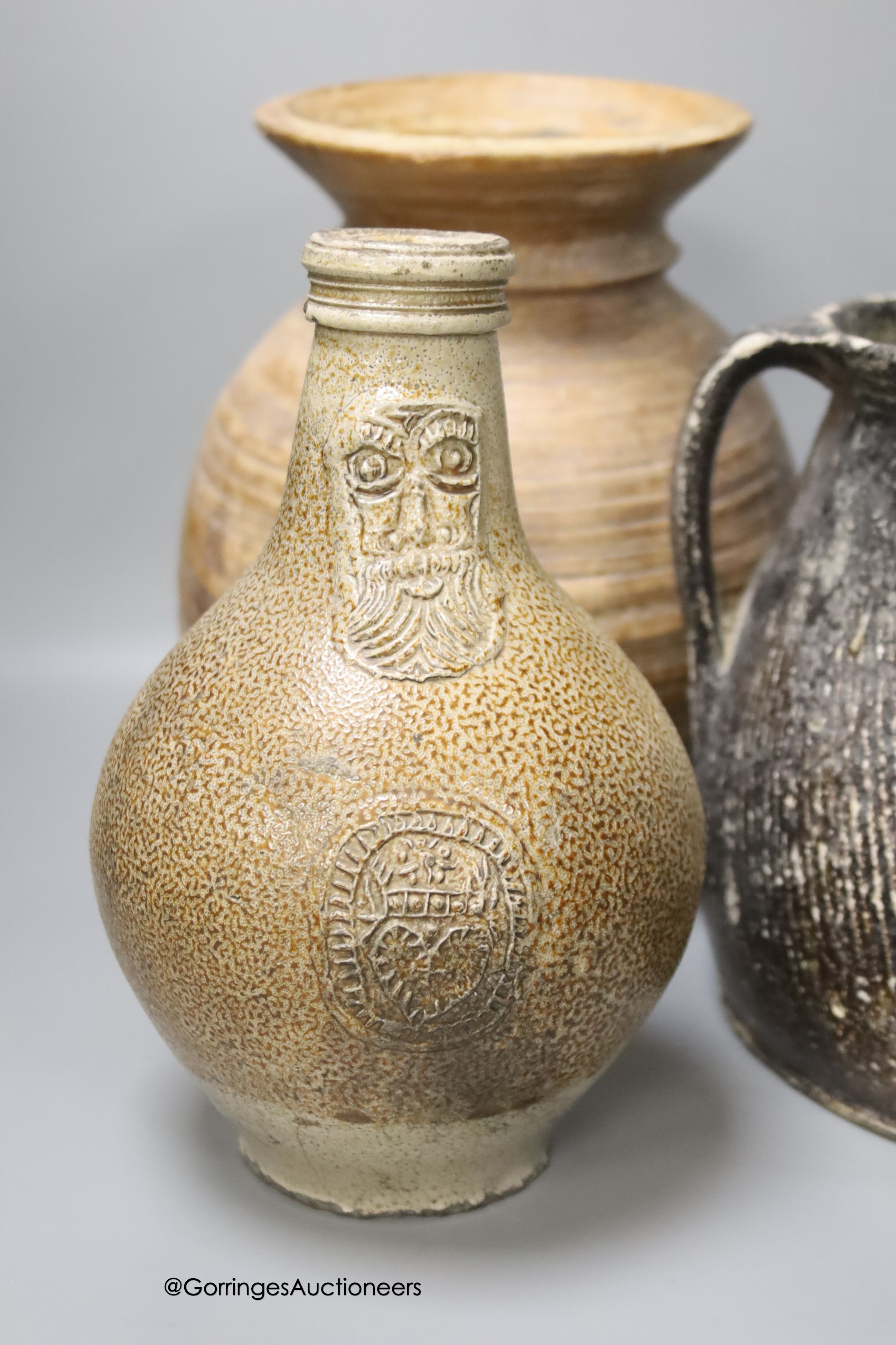 A 17th century continental Tiger ware Bellarmine, 23cm, together with a two handled earthenware bowl, a turned wood bowl and a cylindrical stoneware flask